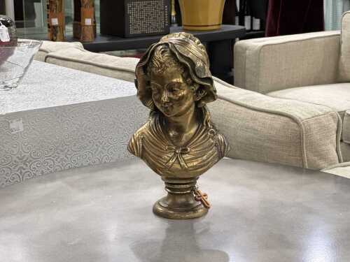 Brass-style bust of a girl wearing a bonnet