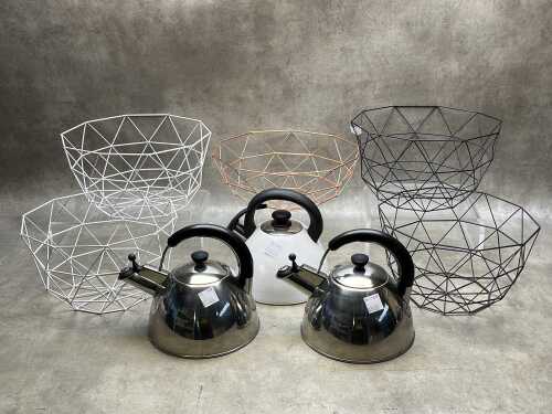 Three contemporary stainless steel kettles and five wire fruit baskets