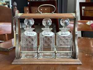 Antique timber tantalus with cut crystal decanters, brass fittings and key