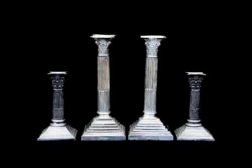 Two pairs of Neoclassical silver plated candlesticks