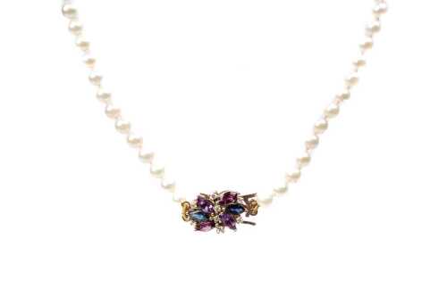 A strand of pearls with an amethyst, sapphire, garnet and diamond clasp in 9 carat yellow gold