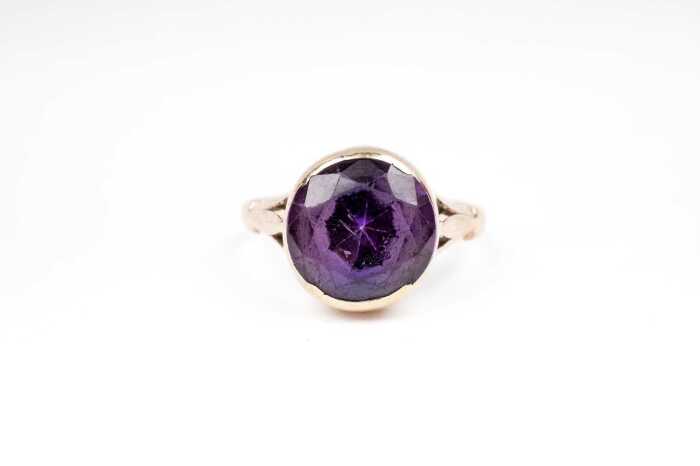 A synthetic purple sapphire ring in 9 carat yellow gold