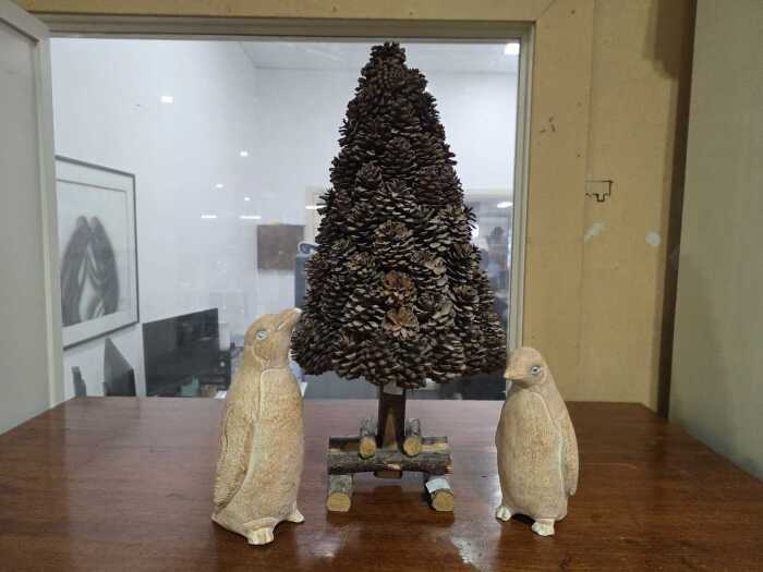 Pinecone tabletop Christmas Tree, together with a pair of plaster penguin figures