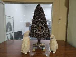 Pinecone tabletop Christmas Tree, together with a pair of plaster penguin figures