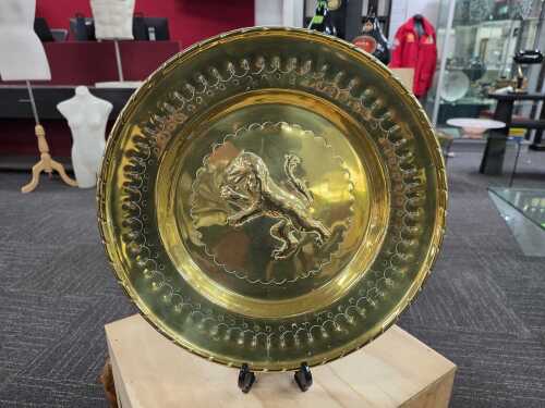 25 · Brass wall plaque with repoussé rampant lion to centre