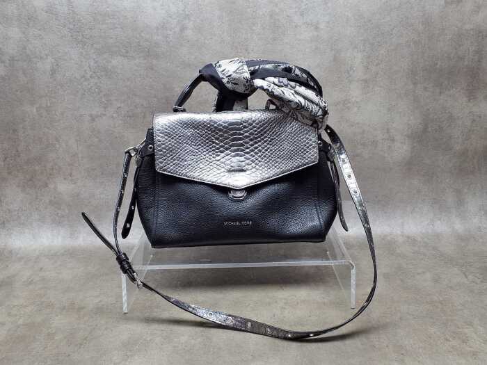 Black handbag with silver-tone hardware and a bag scarf