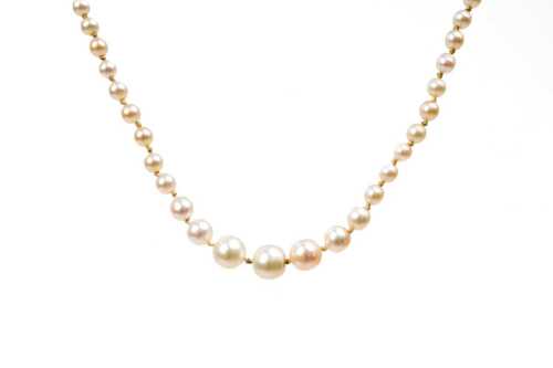 An antique strand of pearls with diamond set silver clasp