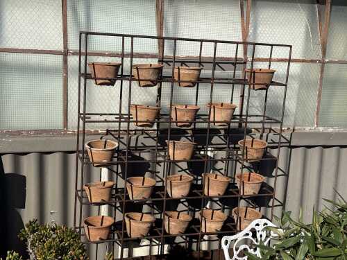 Metal garden pot stand with terracotta pots