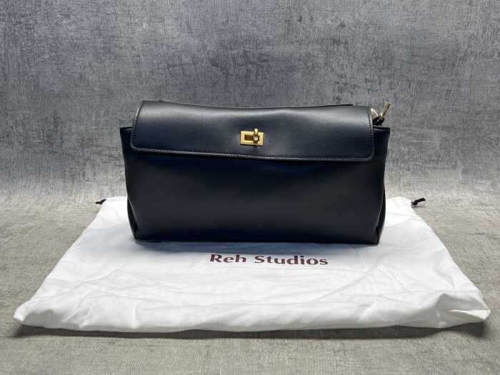 Designer-style black leather handbag with gold-tone hardware.