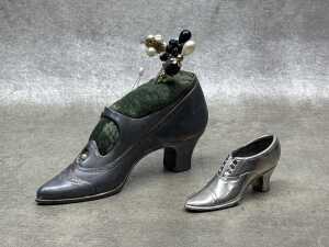 Two cast metal shoes, including a pin cushion with hat pins