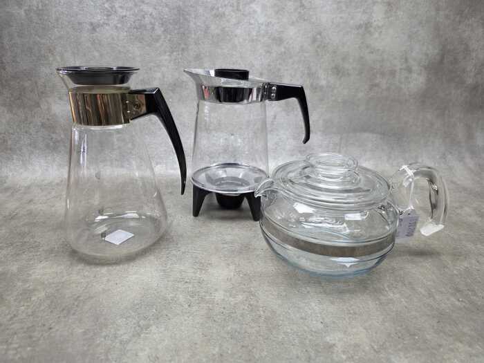 Three retro glass coffee pots including Pyrex, J&J on warming stand, etc.