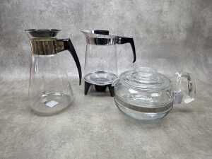 Three retro glass coffee pots including Pyrex, J&J on warming stand, etc.