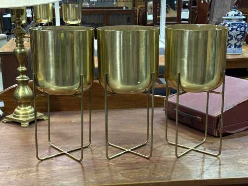 Three gold-tone metal planters on stands
