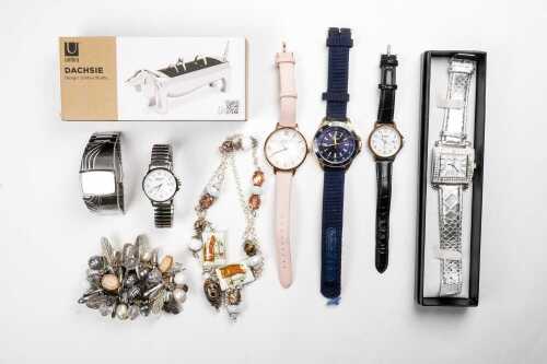 A collection of watches, jewellery and a ring holder.