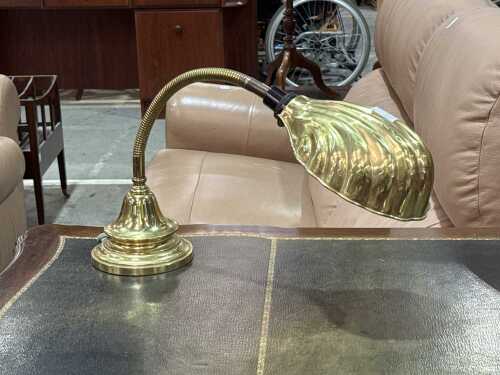 Brass desk lamp with snake stem and shell-shaped shade.