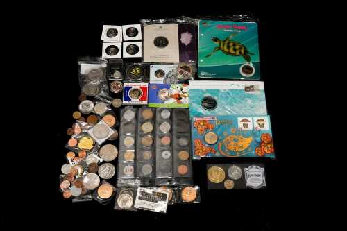A tin of assorted international coins and medallions