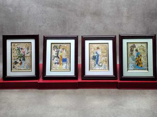 Four boxed Oriental hand-pained metal relief artworks in frames.