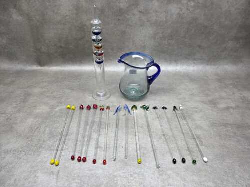 Hand-blown glass swizzle sticks together with a Galileo thermometer