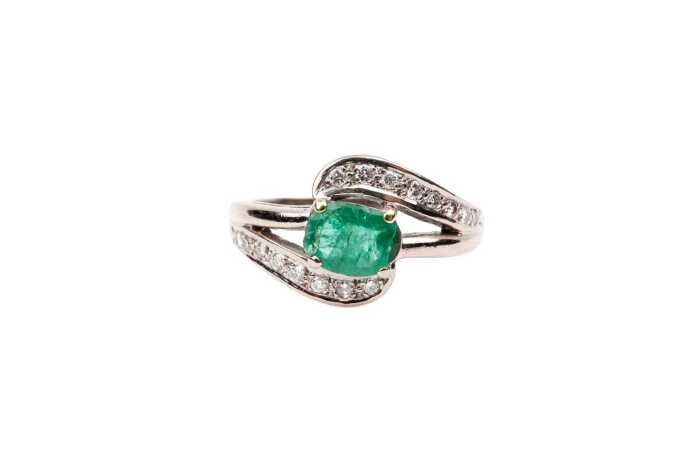 An emerald and diamond ring in 18 carat yellow gold