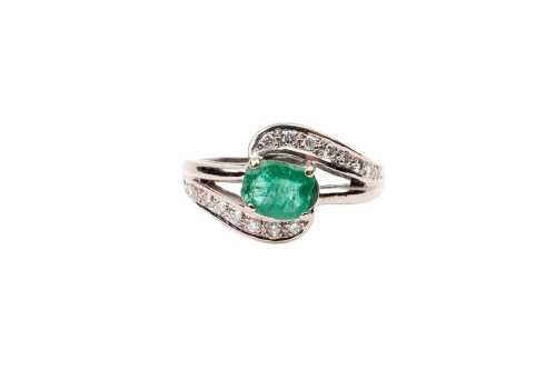 An emerald and diamond ring in 18 carat yellow gold