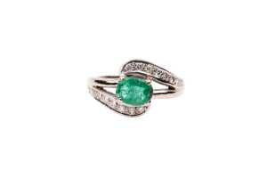 An emerald and diamond ring in 18 carat yellow gold