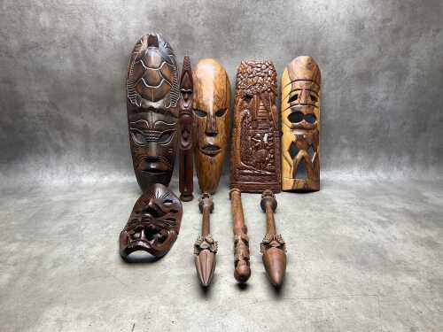 Carved timber decorative items, including masks, wall panels, spears