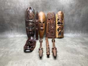 Carved timber decorative items, including masks, wall panels, spears