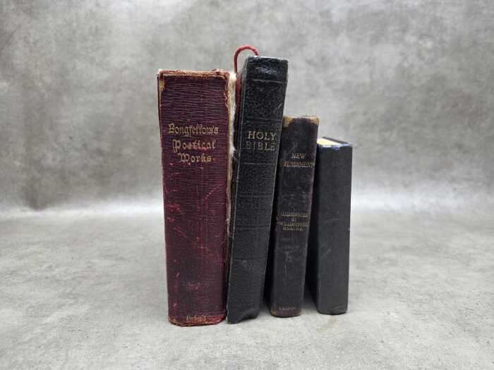 Four antique books, including The New Testament