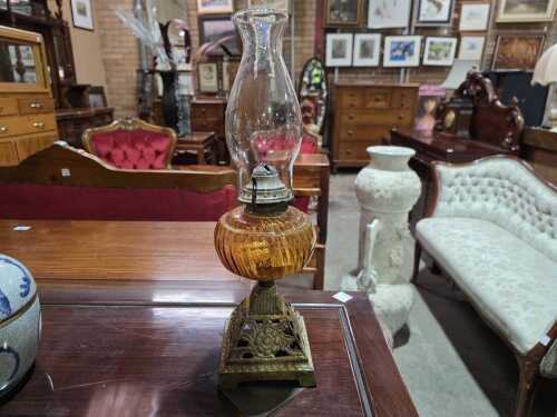 Antique kerosine lamp with amber glass bowl.