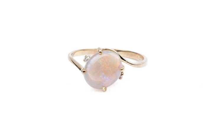 An opal and diamond ring in 9 carat yellow gold