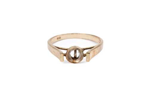 An empty setting in 9 carat yellow gold