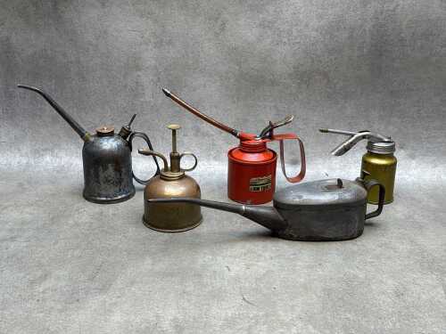 Five garage oil cans, including brass