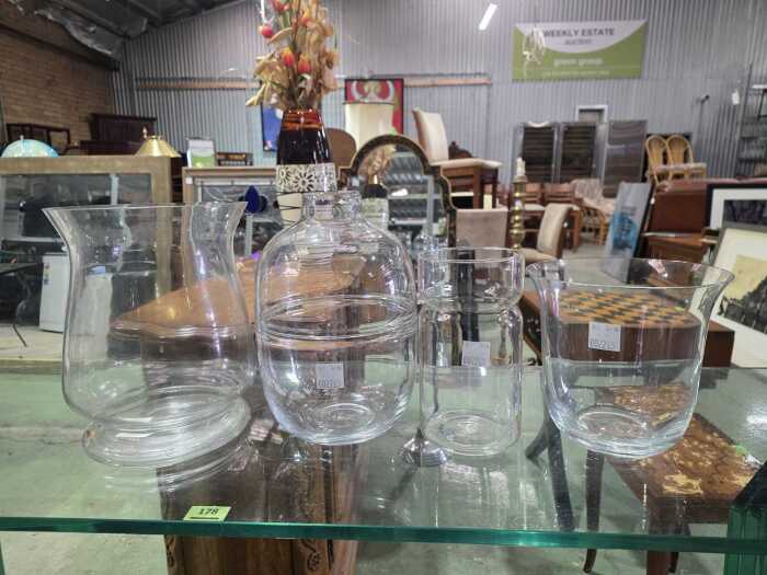 Four clear glass vases in various shapes and sizes