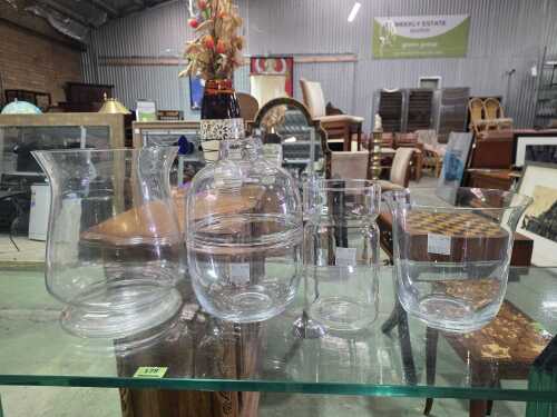 Four clear glass vases in various shapes and sizes