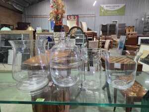 Four clear glass vases in various shapes and sizes