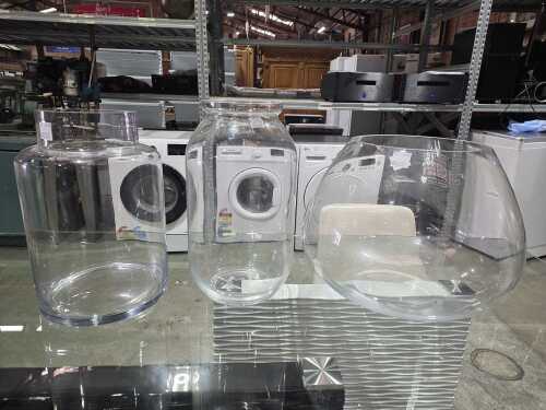 Three clear glass floor vases in various shapes
