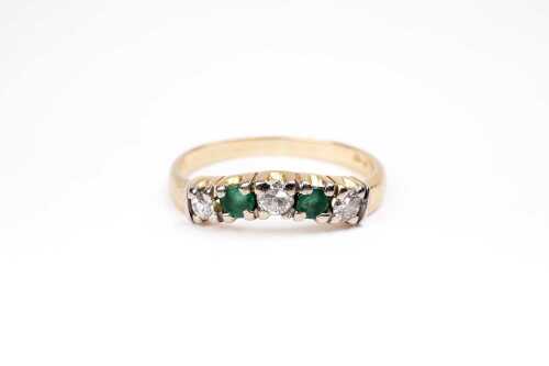 An emerald and diamond ring in 18 carat yellow gold