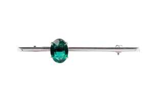 A synthetic emerald brooch in 9 carat white gold