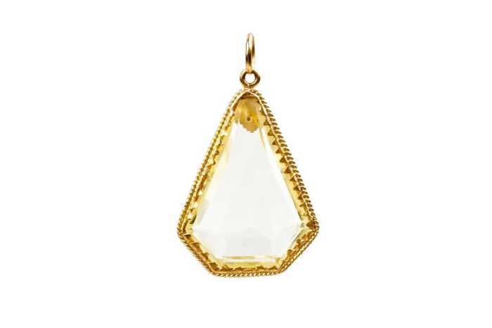 A kite shape yellow glass pendant set in 22 carat yellow gold
