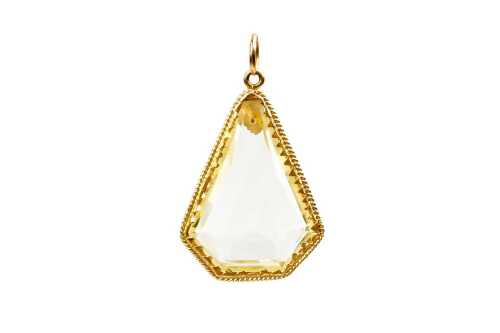 A kite shape yellow glass pendant set in 22 carat yellow gold