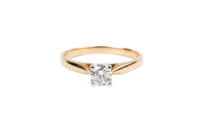 A diamond solitaire ring in 14 carat yellow gold