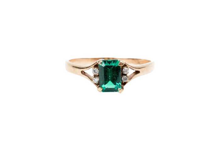 A synthetic emerald and diamond ring in 9 carat yellow gold