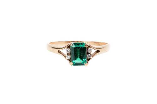 A synthetic emerald and diamond ring in 9 carat yellow gold