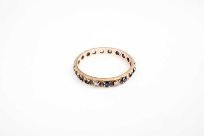 A sapphire and diamond band in 9 carat yellow gold