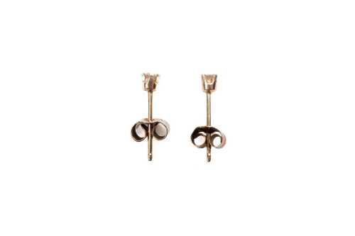 A pair of diamond stud earrings in 9 carat yellow gold