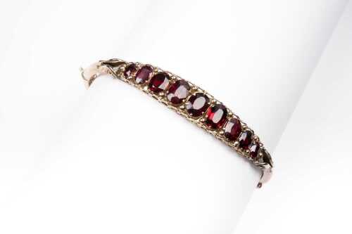 A vintage garnet bangle in 9 carat yellow gold