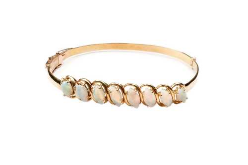 A vintage opal bangle in 14 carat yellow gold