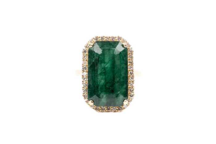 An emerald and diamond ring in 18 carat yellow gold