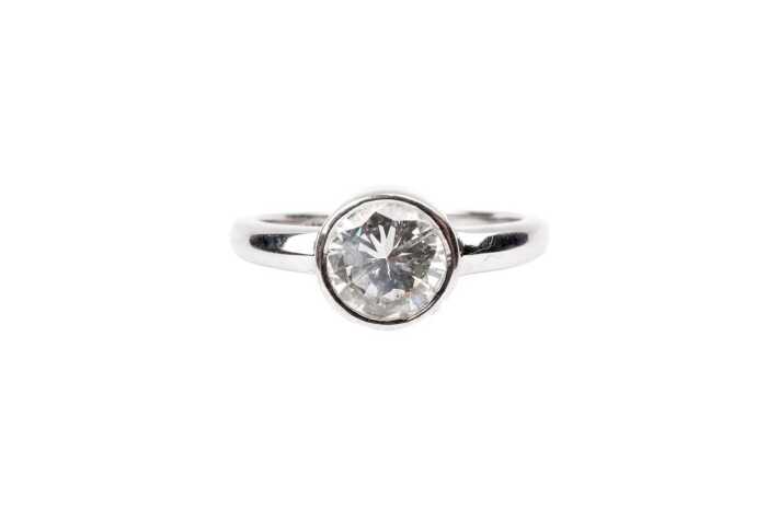 A bezel set solitaire in 18ct white gold