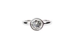 A bezel set solitaire in 18ct white gold